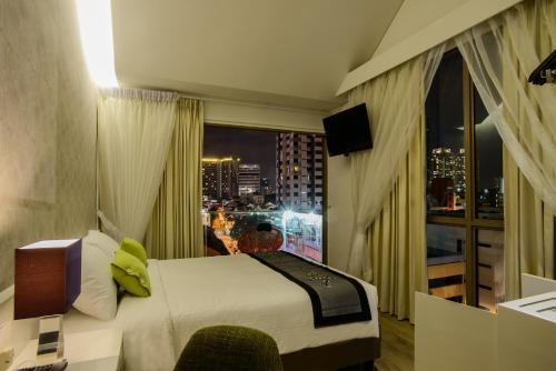 J8 Hotel في سنغافورة: غرفة فندقية بسرير ونافذة كبيرة