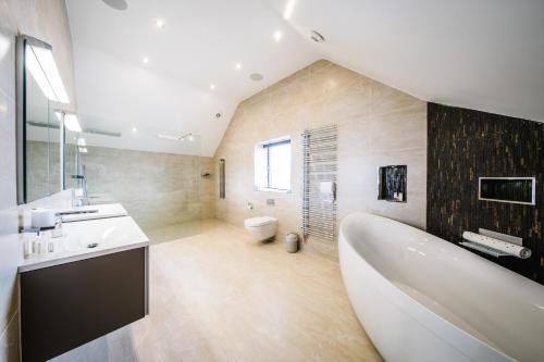 y baño con bañera, lavabo y aseo. en Carus House @ Carus Green, en Kendal
