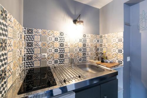 Il dispose d'une cuisine avec un évier et un mur carrelé. dans l'établissement LE CARRÉ MATABIAU HYPERCENTRE GARE NETFLIX, à Toulouse