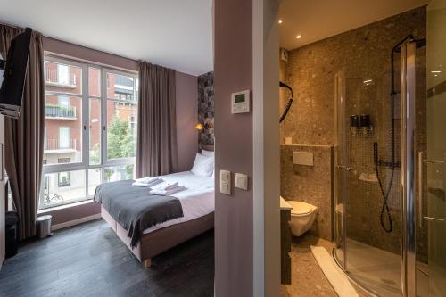 Un dormitorio con una cama y un baño con ducha. en Dock 29, en Amberes