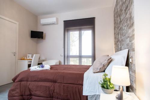 - une chambre avec un lit et un mur en briques dans l'établissement Brio Bed & Breakfast, à Agrigente