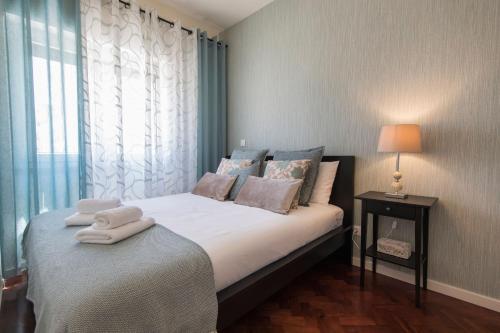 a bedroom with a bed with towels on it at Bairrus Lisbon Apartments - Duque in Lisbon