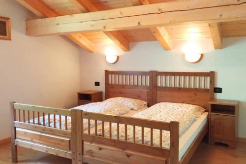 a bedroom with a wooden bed in a room with wooden ceilings at La Majon in Colle Santa Lucia