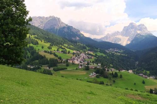 a small town in a green valley with mountains at La Majon in Colle Santa Lucia