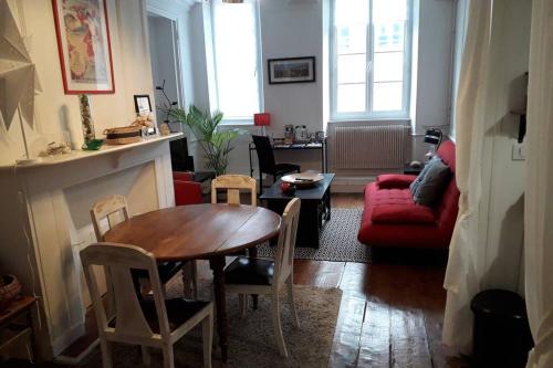 un salon avec une table et un canapé rouge dans l'établissement Appartement la haute ville Granville, à Granville