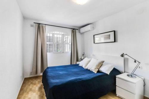 Un dormitorio con una cama azul y una ventana en Verano Azul, 2 bedroom with Free Wi-fi, en Nerja