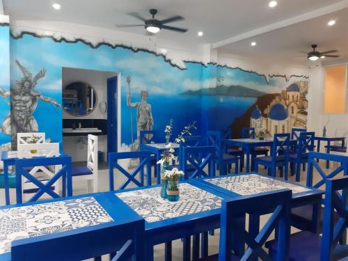 uma sala de jantar com mesas azuis e um mural em Skytel Palawan em Puerto Princesa