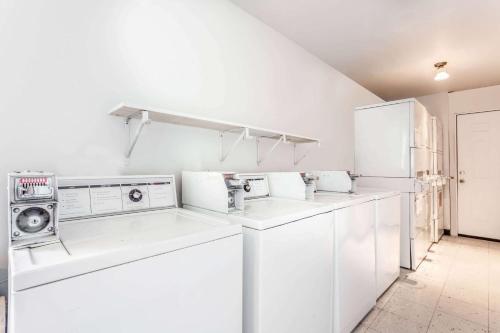 a white laundry room with washing machines and appliances at Days Inn by Wyndham Ellensburg in Ellensburg