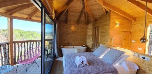 a bedroom with a bed and a balcony with a tub at Les Suites in Santa María de Palautordera