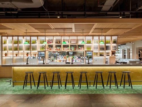 a bar in a restaurant with stools at Novotel York Centre in York