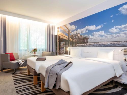 a bedroom with a large white bed and a large window at Novotel Hamburg City Alster in Hamburg