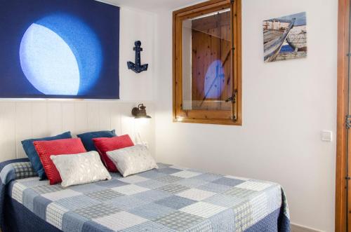 1 dormitorio con 1 cama con almohadas rojas y azules en Apartment Oscar, en Sitges