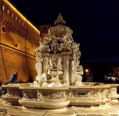 a large stone fountain in front of a building at Casa Dora in Cesena