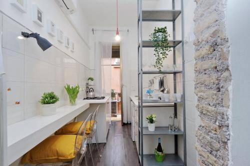 una cucina con pareti bianche e bancone con piante di Urbana Delicious Flat a Roma