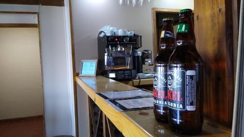 duas garrafas de cerveja sentadas num balcão num quarto em Altos de Soberana em El Calafate
