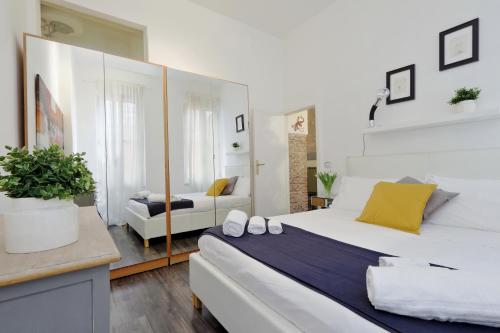 una camera da letto con un grande letto bianco e un divano di Urbana Delicious Flat a Roma