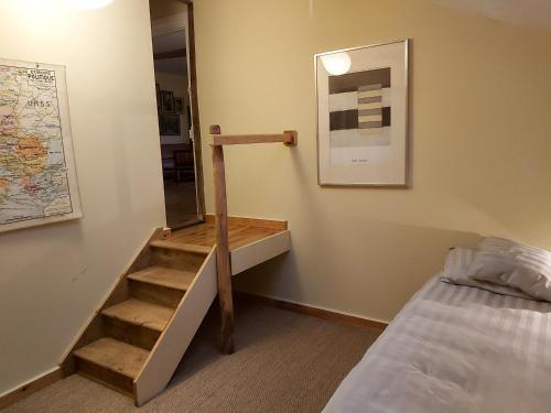 a room with a staircase next to a bed at Brocante Heaven 2 in Aignan