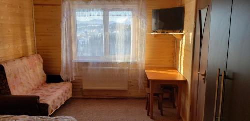 a room with a window and a desk and a table at Marichka in Yablunytsya