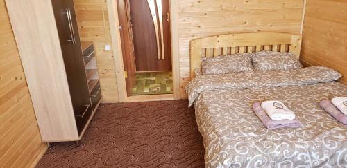 a bedroom with a bed in a wooden room at Marichka in Yablunytsya