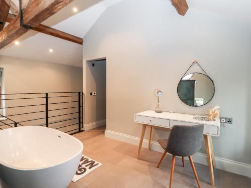 un bagno con vasca, lavandino e specchio di The Old Workshop a Denbigh