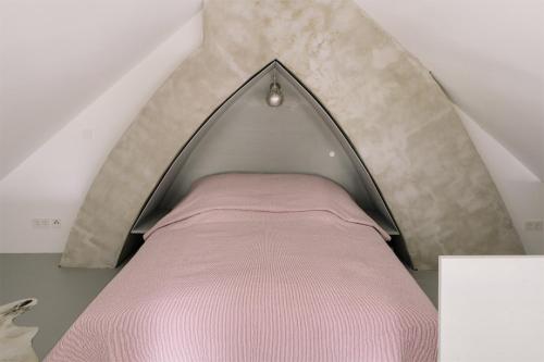 a bedroom with a pink bed in the attic at Apartment im Kranich Hotel in Hessenburg