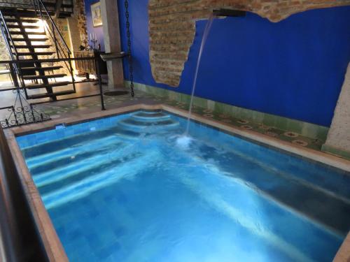 a large swimming pool with a blue wall at Hotel Boutique La Solera Del Pozo in Santa Marta