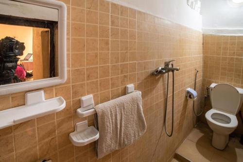 een badkamer met een toilet, een wastafel en een spiegel bij Dar Najia in Fès