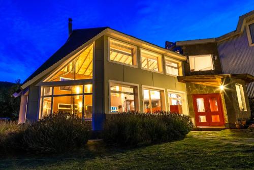 ein Haus mit vielen Fenstern in der Unterkunft Pudu Lodge in El Chalten