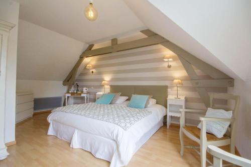 ein Schlafzimmer mit einem weißen Bett auf einem Dachboden in der Unterkunft Ty Coz Breizh Chambres d'hôtes in Guidel