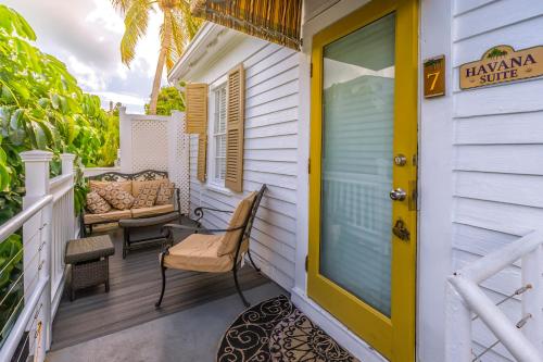 a front porch of a house with a yellow door at Seascape Tropical Inn in Key West