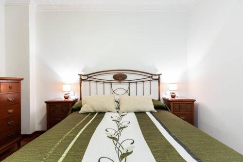 a bedroom with a bed with two dressers and two lamps at APARTAMENTO EN A ESTRADA/GALICIA in A Estrada