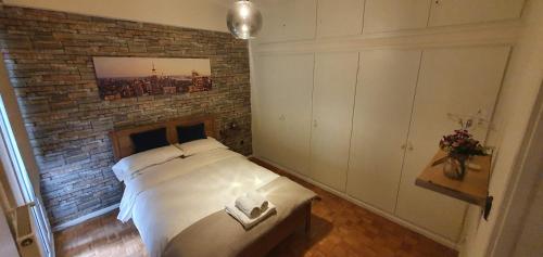 um quarto com uma parede de tijolos e uma cama em Sofia Urban Acropolis Appartment em Atenas