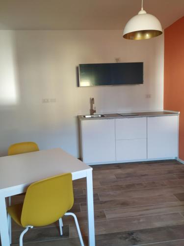 a room with a white table and chairs and a tv at Pause Lake Garda in San Giorgio