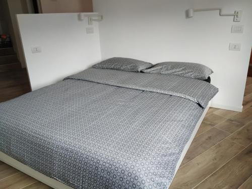 a bed in a white room with two pillows at Pause Lake Garda in San Giorgio