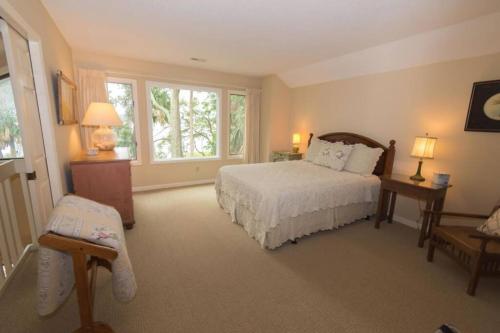 ein Schlafzimmer mit einem weißen Bett und einem Fenster in der Unterkunft Pristine 3 Bedroom Dataw Bluff Villa in Dataw Island