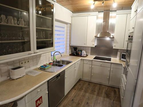 a kitchen with white cabinets and stainless steel appliances at Landhaus Schlossberg in Medebach