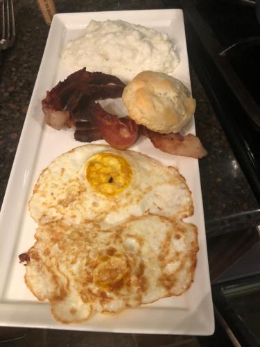 a plate of breakfast food with eggs bacon and potatoes at The Montgomery B&B in Starkville