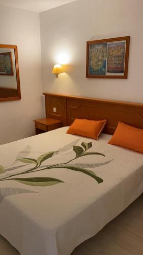 1 dormitorio con 1 cama con almohada naranja en villas Canarias, en Adeje