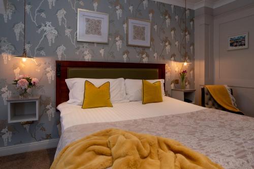 a bedroom with a large bed with yellow pillows at Whitford House Hotel in Wexford
