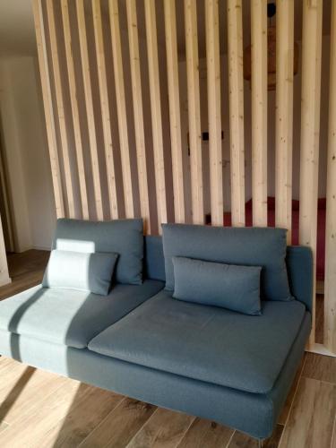 a blue couch with pillows in a room at Pause Lake Garda in San Giorgio