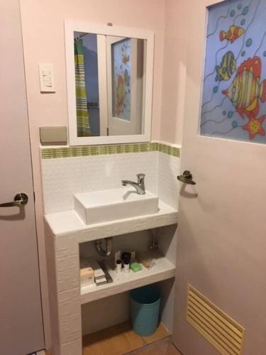 a bathroom with a sink and a mirror at Magayon Pink House in Legazpi