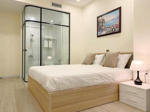 a bedroom with a large bed and a shower at 8B Aparthotel in Ho Chi Minh City