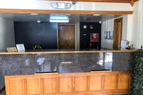 Econo Lodge في مدينة اوكلاهوما: كونتر مع مرآة كبيرة في الغرفة