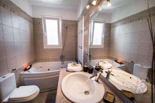 a bathroom with a sink and a tub and a toilet at VILLA FAIRIES in Lygia
