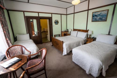 um quarto de hotel com duas camas e uma mesa e cadeiras em Coolcower House em Macroom