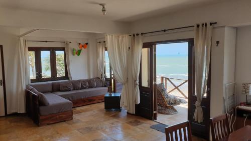 a living room with a couch and a view of the ocean at Penthouse Apartment Cumbuco - Tee's Beach Palace in Cumbuco