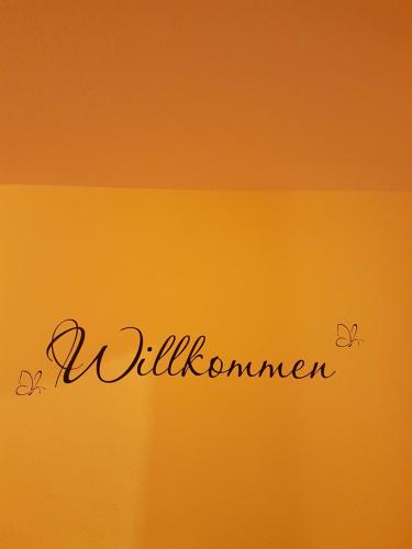 a sign with the word willushima written on an orange background at Scharfer Kessel in Weimar