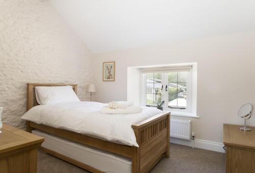 a bedroom with a large bed and a window at Alysas Cottage in Chipping Norton