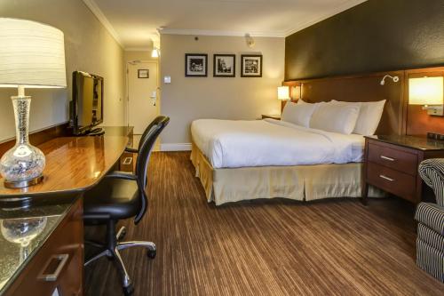 a hotel room with a bed and a desk at La Saguenéenne - Hôtel et Centre de Congrès in Saguenay