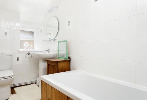 a white bathroom with a sink and a toilet at Church Cottage in Chipping Norton